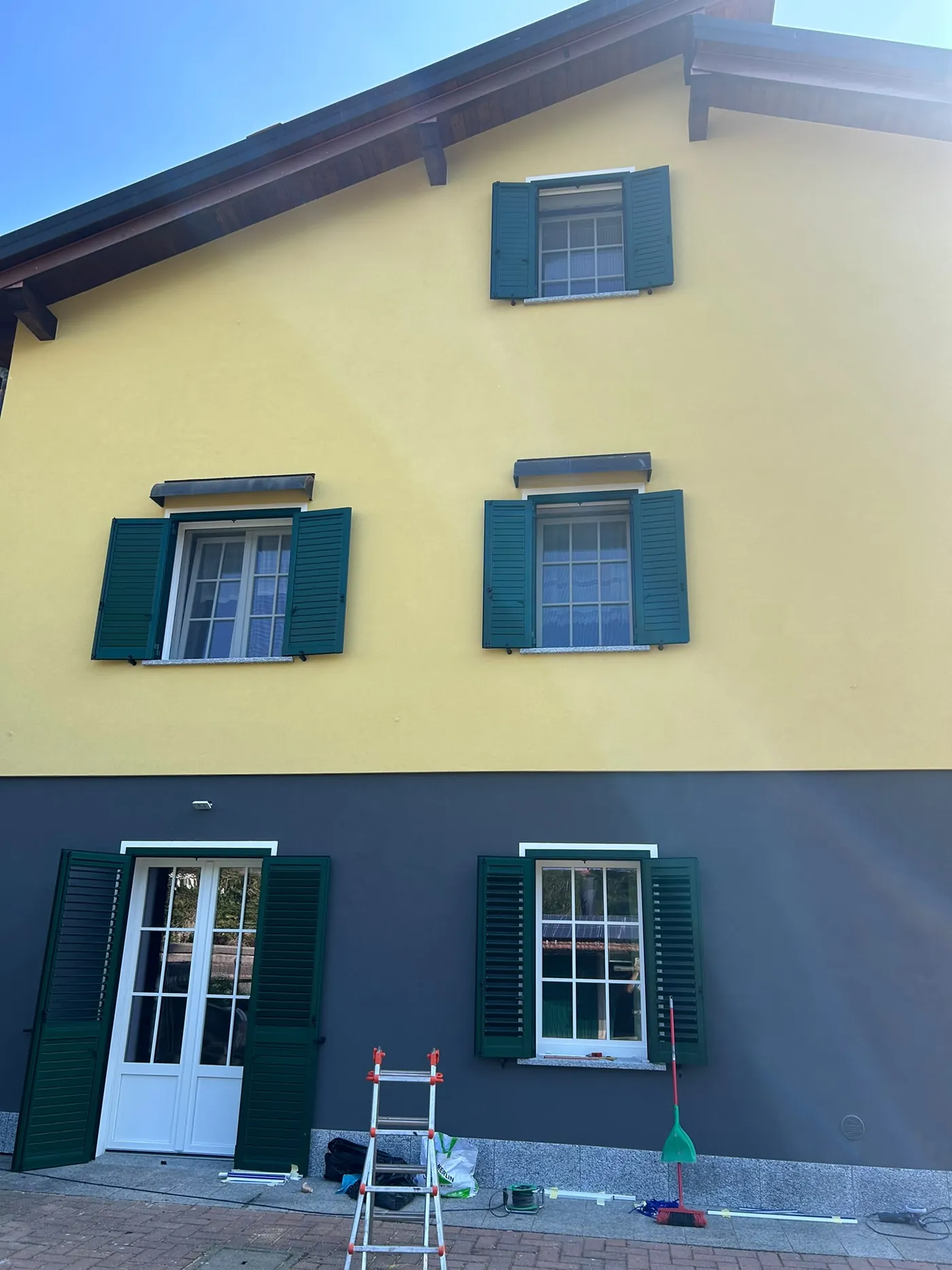 Casa di campagna con serramenti restaurati e scuri verdi tradizionali