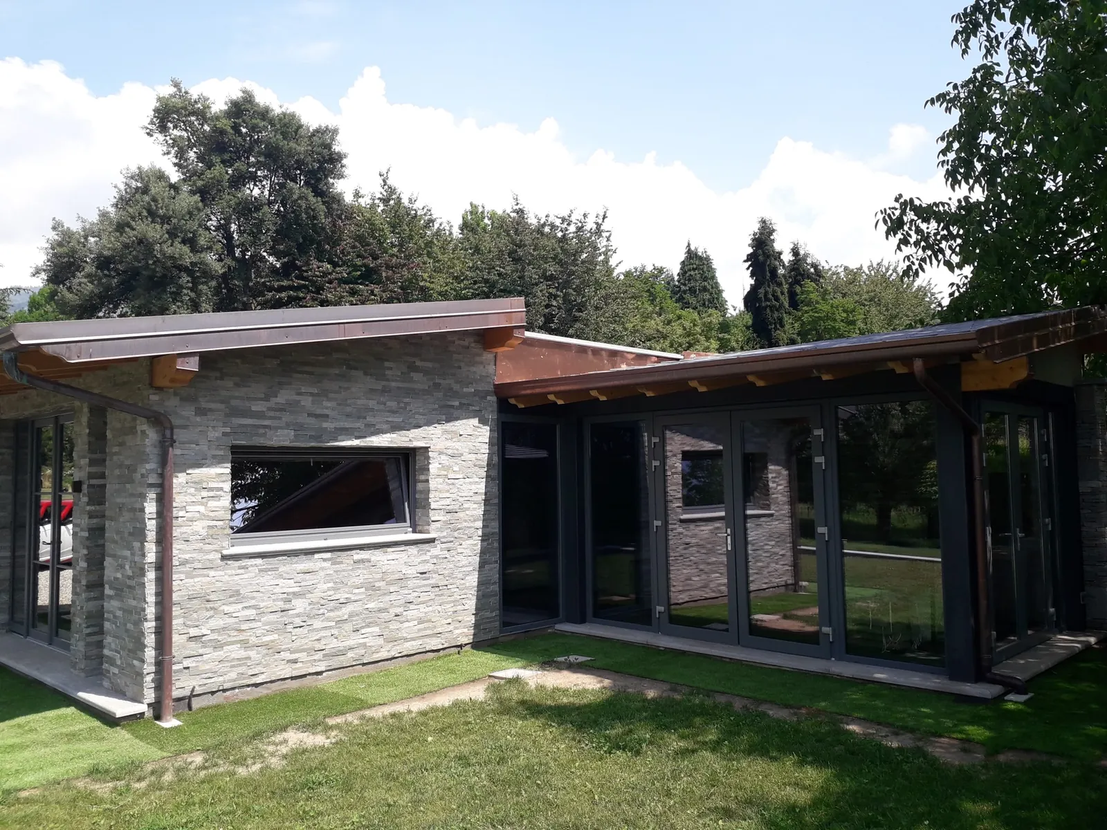 Villa moderna con grandi vetrate scorrevoli e rivestimento in pietra